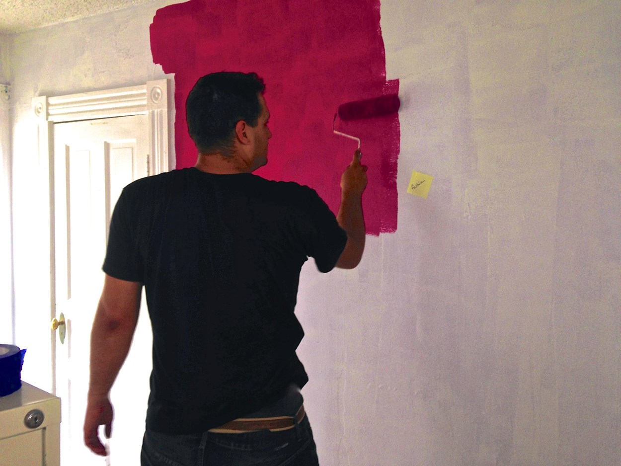 Jonathan painting a wall in a home for re-housing a family